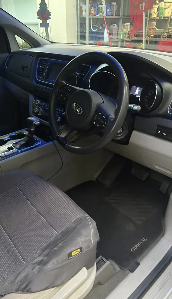 The same Kia Carnival front seat and floor mat after the detail, clean